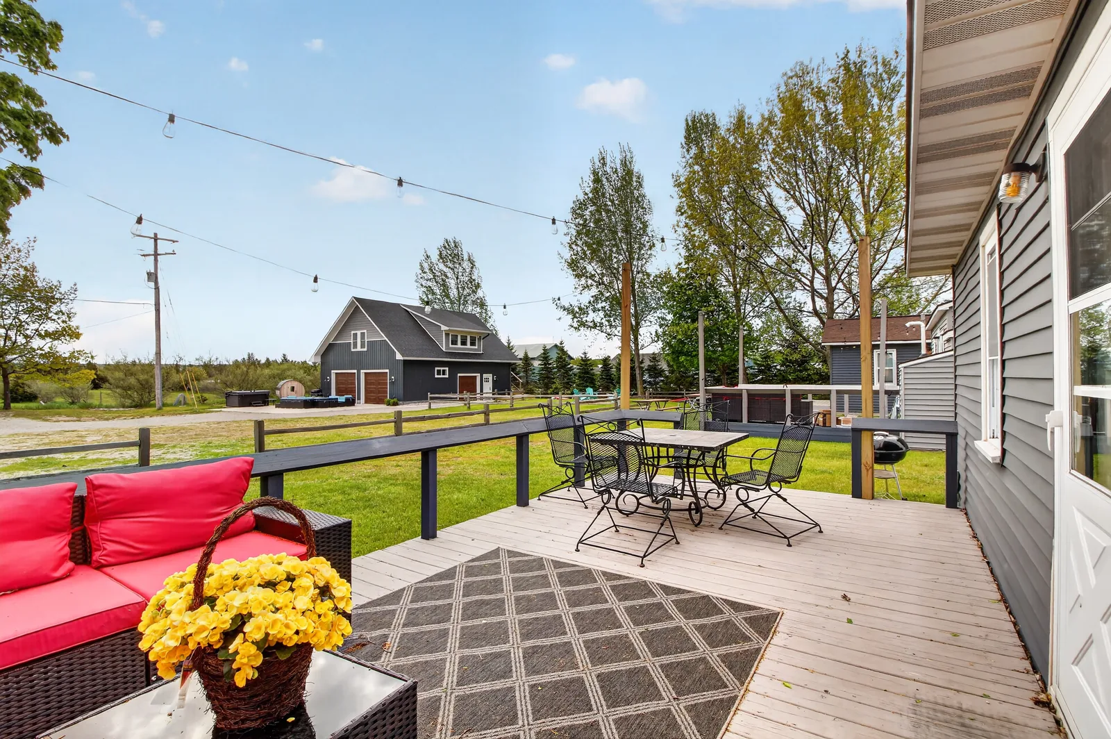 Private deck with red sectional and view to the barn