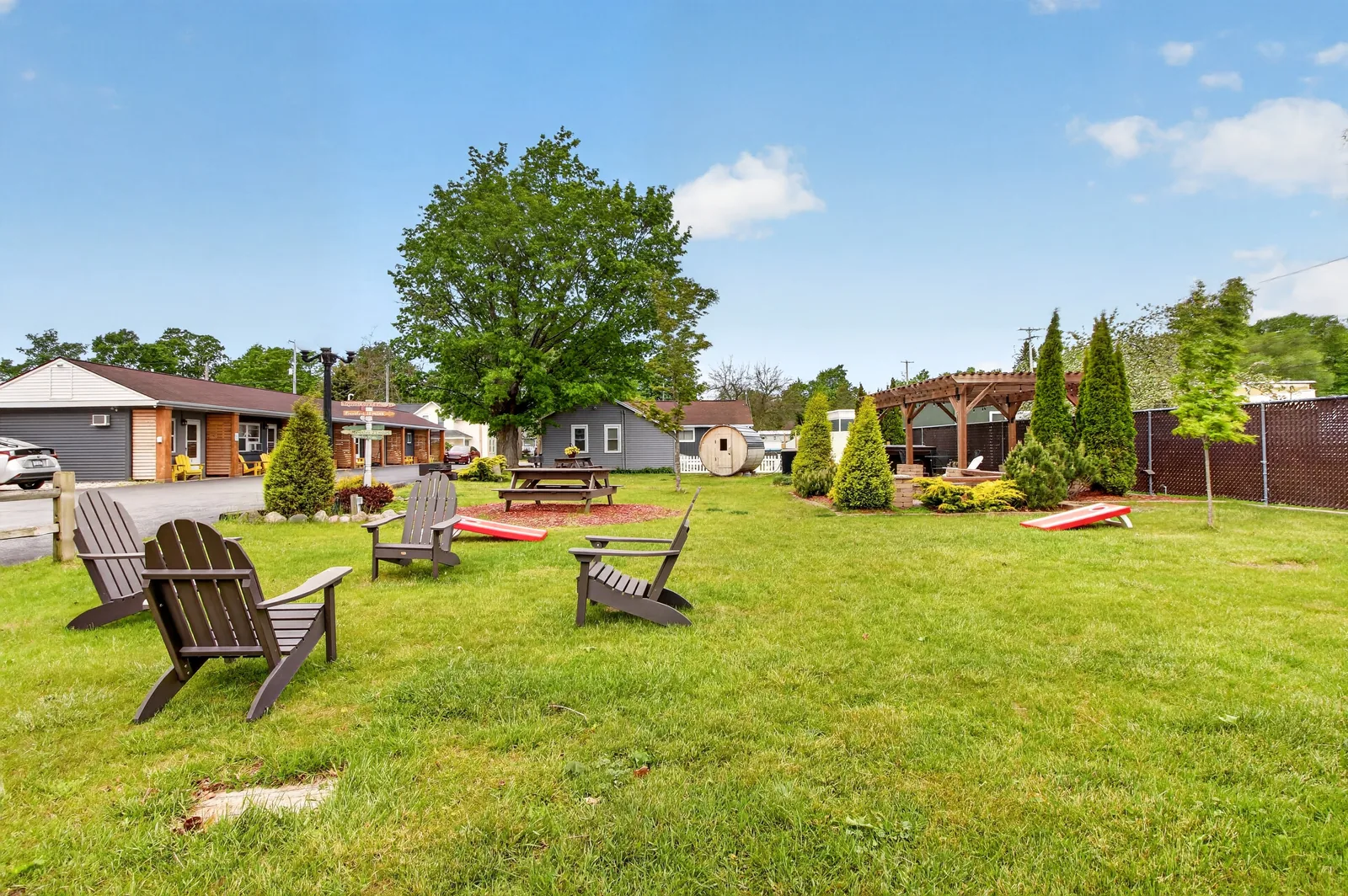 Resort lawn with Adirondack chairs, picnic table, and barrel sauna