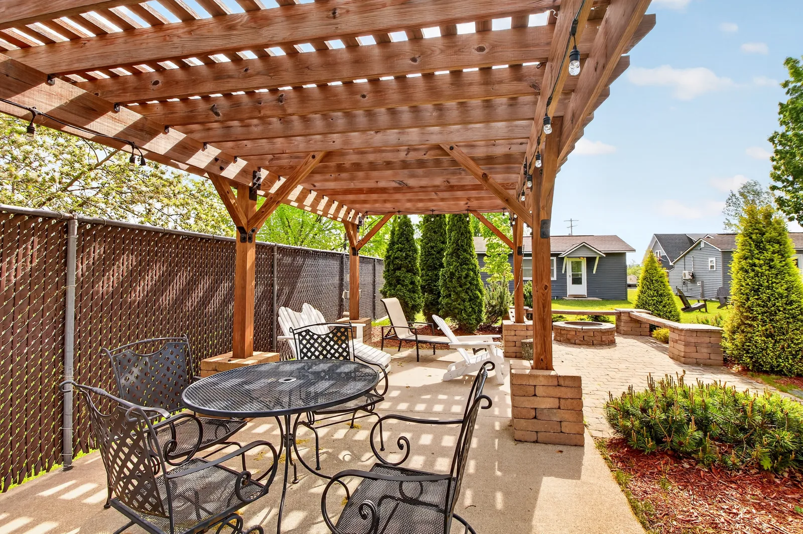 Pergola with outdoor dining set and string lights